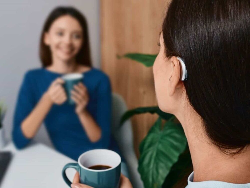 Woman wearing a receiver-in-canal hearing aid, one of the styles fitted at Advanced EARGEAR in Akron, OH